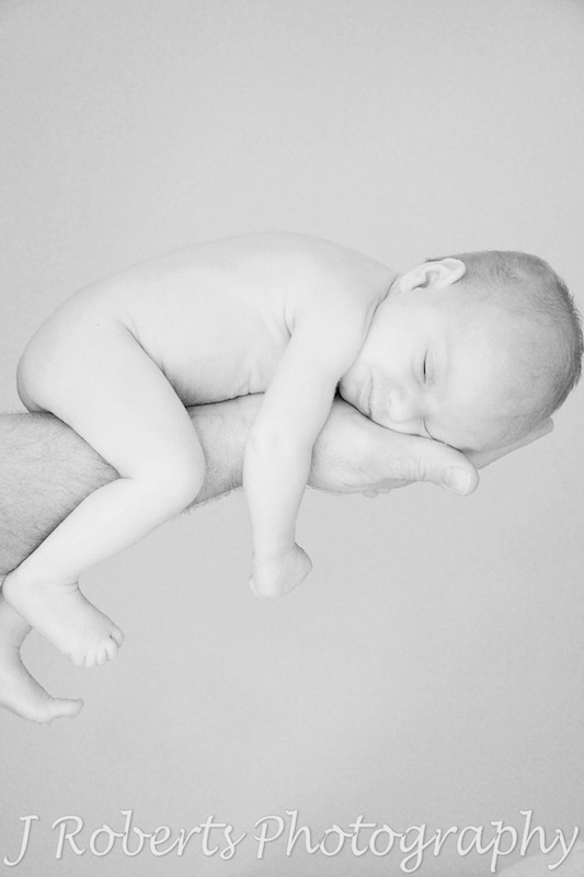 Newborn baby sleeping over father's arm - newborn baby portrait photography sydney